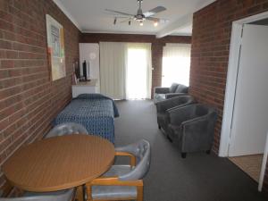 a room with a table and chairs and a brick wall at Tocumwal Golf Resort in Tocumwal