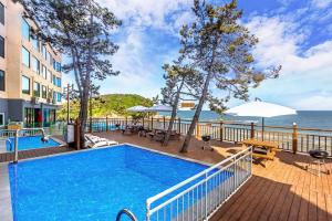 扶安Soleiview Spa Pension and Resort的一座游泳池毗邻一座建筑和大海