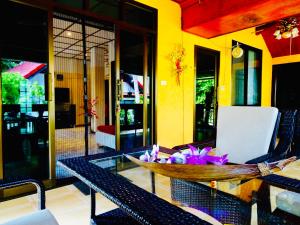 une table en verre avec des fleurs au-dessus d'une pièce dans l'établissement Starbay Samui, à Lamai