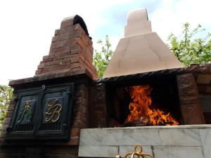 a brick oven with a fire in it at Leaganul Bucovinei Guest House in Suceava