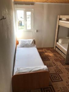 a small room with two beds and a window at Comfort Guest House in Borovoye +33 photos