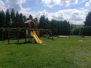 a playground with a slide and a swing set in a yard at Salt Mine Apartment 64m2 in Wieliczka
