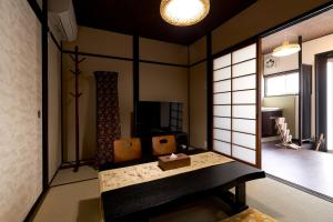 Zimmer mit weißen Wänden und einem Tisch in der Unterkunft 憩 出町柳２(ikoi DemachiyanagiⅡ) in Kyoto