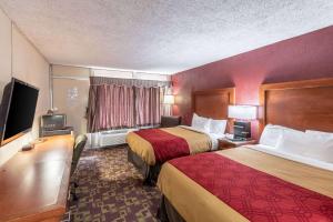 a hotel room with two beds and a flat screen tv at Econo Lodge in Zanesville