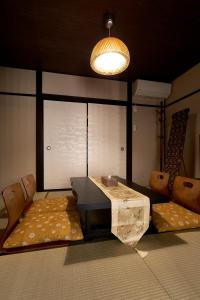 憩 出町柳２(ikoi DemachiyanagiⅡ) في كيوتو: غرفة معيشة مع طاولة وكراسي وأريكة