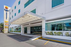 a white building with awning on the side of it at Comfort Inn Morelia in Morelia