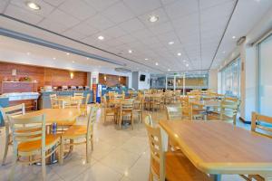 une salle à manger avec des tables et des chaises en bois dans l'établissement Comfort Inn Morelia, à Morelia