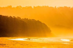 two people standing on a beach near the water at Taj Exotica Resort & Spa, Andamans in Havelock Island