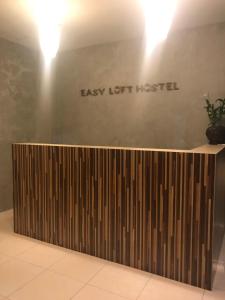 a reception desk with a sign that reads easy left hottest at Easy Loft Hostel in Phuket