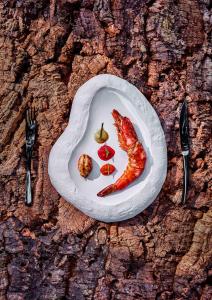 a plate of food with a shrimp and vegetables on a table at Taj Exotica Resort & Spa, Andamans in Havelock Island
