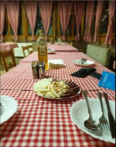 a table with a plate of food on a red and white table cloth at Domacinstvo Kod Gere in Crni Vrh