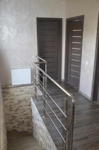 a staircase with a metal railing next to two doors at Royal House in Kamianets-Podilskyi