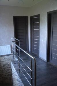 a staircase with a metal railing next to two doors at Royal House in Kamianets-Podilskyi