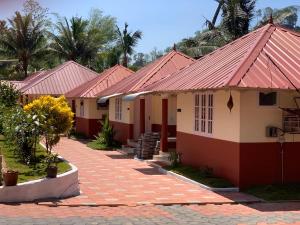 a row of houses with red roofs at Kandamath Heritage Resort in Kolattupuzha