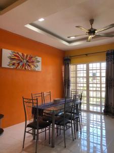 a dining room with a table and chairs and a ceiling fan at SELESA Holiday Home in Kuala Terengganu
