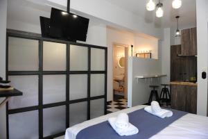 a bedroom with a bed with a tv on the wall at Candy's Boutique Rooms in Asprovalta