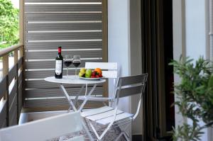 a table with a plate of fruit and a bottle of wine at Candy's Boutique Rooms in Asprovalta +17 photos