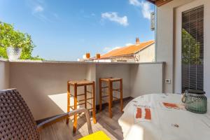 a balcony with a table and chairs and a view at Apartment Hasanec by El-Pi Tours in Njivice