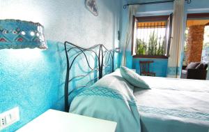 a bedroom with a bed with blue walls at SU PASSU Country House in Fertilia