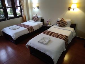 a hotel room with two beds with towels on them at Butterfly Lodge in Pokhara