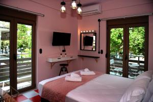 a bedroom with a bed and a sink and a television at Candy's Boutique Rooms in Asprovalta