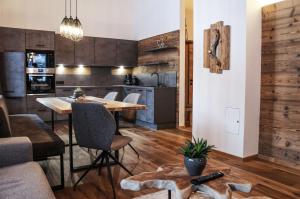 a kitchen and living room with a table and chairs at Zeitfrei Chalet Apartments in Fieberbrunn