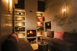 a living room with a couch and a fireplace at Riad Cinnamon by Marrakech Riad in Marrakesh