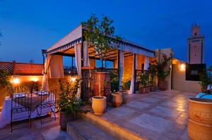 a house with a patio with a table and chairs at Riad Cinnamon by Marrakech Riad in Marrakesh