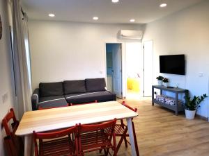 a living room with a couch and a table and chairs at SunnySpainHolidays Apartments in Málaga