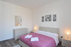 1 dormitorio con 1 cama rosa grande y 2 mesitas de noche en Appartamenti Casa La Rosa, en Bellagio