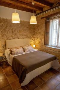 um quarto com uma cama grande e 2 luzes em Casa Rural Puerto Sanz em Zazuar