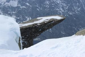 Una roccia che spunta dalla neve su una montagna di Røldalstunet Overnatting a Røldal
