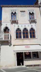 a tall building with windows and a store at Benecanka Casa Veneziana Piran in Piran