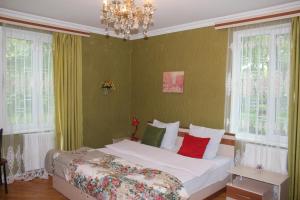 a bedroom with a bed with white sheets and red pillows at Family Hotel Lago & Wine Cellar in Lagodekhi