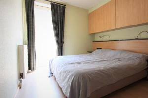 a bedroom with a bed and a large window at Westhinder apt 301 in Nieuwpoort