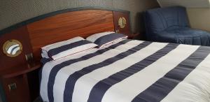 a bedroom with a bed and a blue chair at Les Ondines in Saint-Guénolé +27 photos