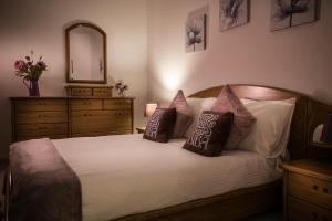 um quarto com uma cama com almofadas e um espelho em Manor Court Luxury Apartment em St. Paul's Bay