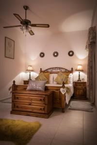 um quarto com uma cama de madeira e 2 mesas de cabeceira em Manor Court Luxury Apartment em St. Paul's Bay