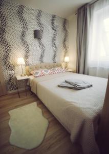 a bedroom with a bed and a window and a rug at Jauki studija su dideliu balkonu Nidos centre in Nida