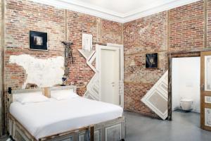 a bedroom with a brick wall and a bed at B&B DRUUM in Brussels