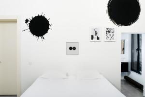 a white room with a bed and pictures on the wall at B&B DRUUM in Brussels