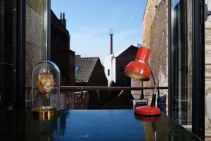 une table avec une lampe rouge et un lion dans une fenêtre dans l'établissement B&B DRUUM, à Bruxelles