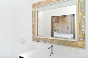 a mirror above a sink in a bathroom at B&B DRUUM in Brussels
