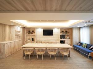 a living room with a large table and a blue couch at Sotetsu Fresa Inn Ueno-Okachimachi in Tokyo