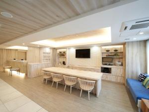 a large kitchen with a large table and chairs at Sotetsu Fresa Inn Ueno-Okachimachi in Tokyo