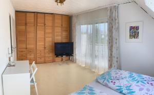 sypialnia z łóżkiem, telewizorem i oknem w obiekcie Schöne Zimmer im Zentrum Leben w mieście Offenburg