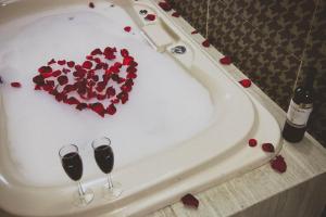 eine Badewanne mit zwei Gläsern Wein und einem Herz in der Unterkunft Hotel Rincon del Cielo in San Juan de los Lagos