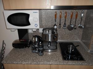 um balcão de cozinha com comodidades para preparar café e um micro-ondas em Студио D-41 в Апарт-хотел Боровец Гардънс em Borovets