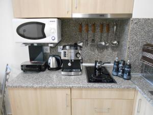 a kitchen counter with a coffee maker and a microwave at Студио D-41 в Апарт-хотел Боровец Гардънс in Borovets