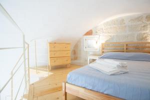 a bedroom with a blue bed and a staircase at Casa Polignano in Polignano a Mare